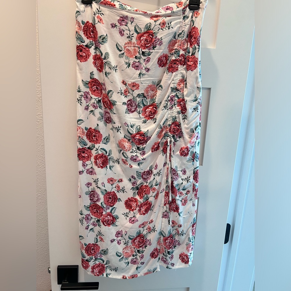 White floral skirt with slit. Slit is adjustable. Not stretchy at all.